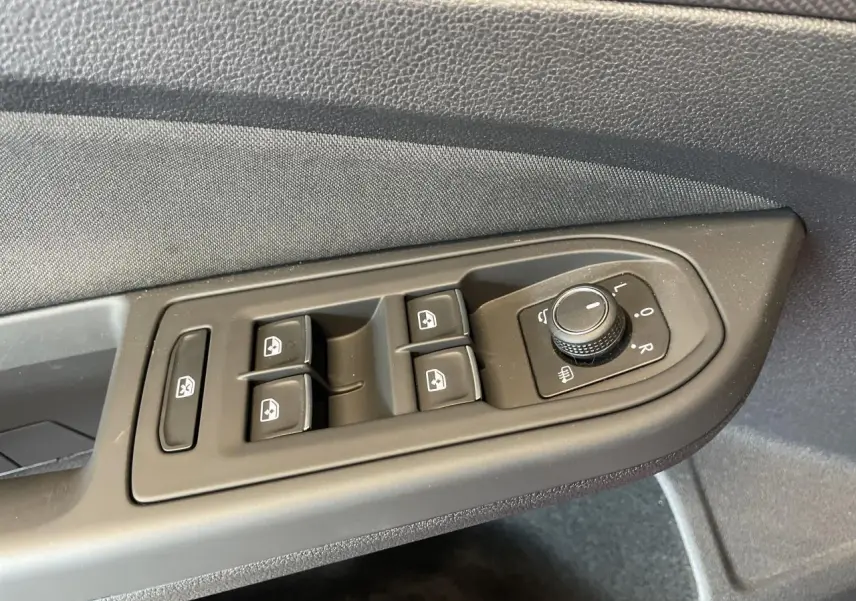 Panneau de commande des vitres et rétroviseurs côté gauche intérieur d'une Volkswagen Golf rouge métallisée 2022.