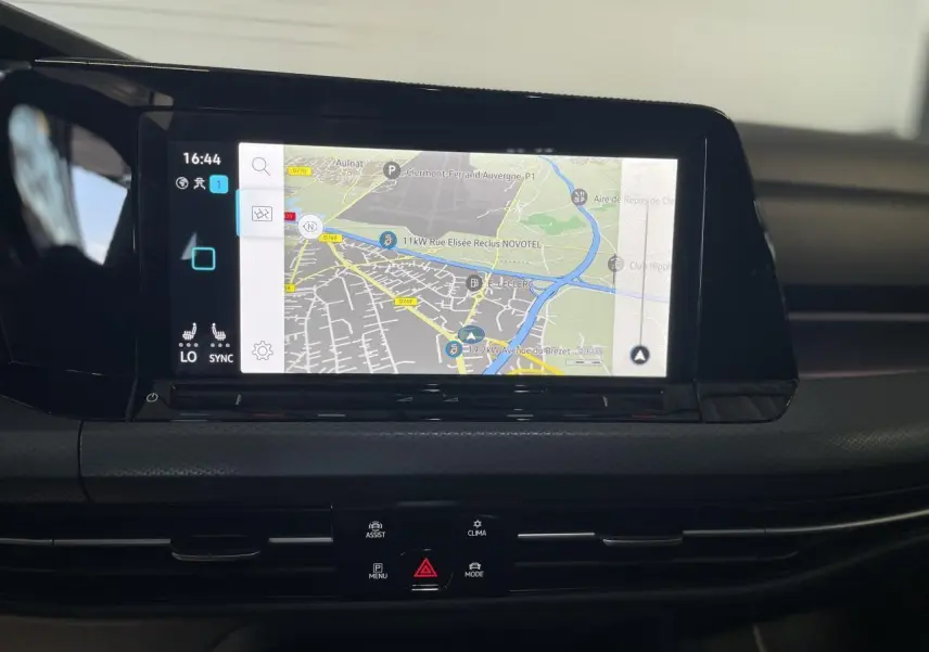 Écran tactile central affichant la navigation dans l'habitacle d'une Volkswagen Golf rouge métal 2022.
