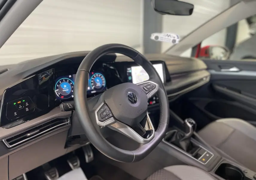 Intérieur de la Volkswagen Golf 1.5 TSI 2022, vue du volant cuir multifonction et tableau de bord digital.