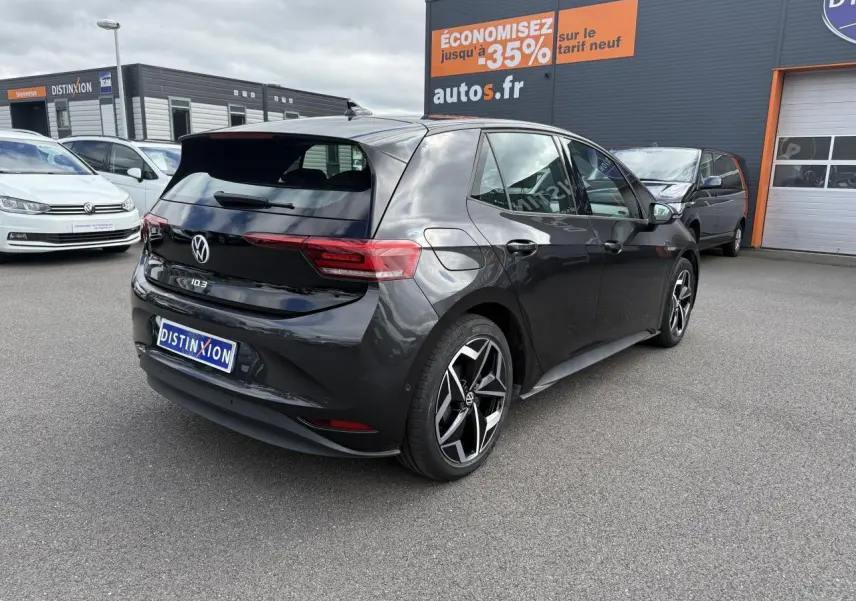 Vue 3/4 arrière droite d'une Volkswagen ID.3 Pro S gris manganèse avec toit noir, sur parking de concession.