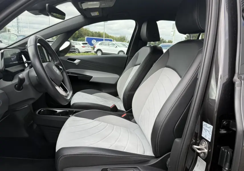 Vue intérieure côté gauche avant du Volkswagen ID.3 Pro S avec sièges bicolores gris clair et noir en tissu et similicuir.