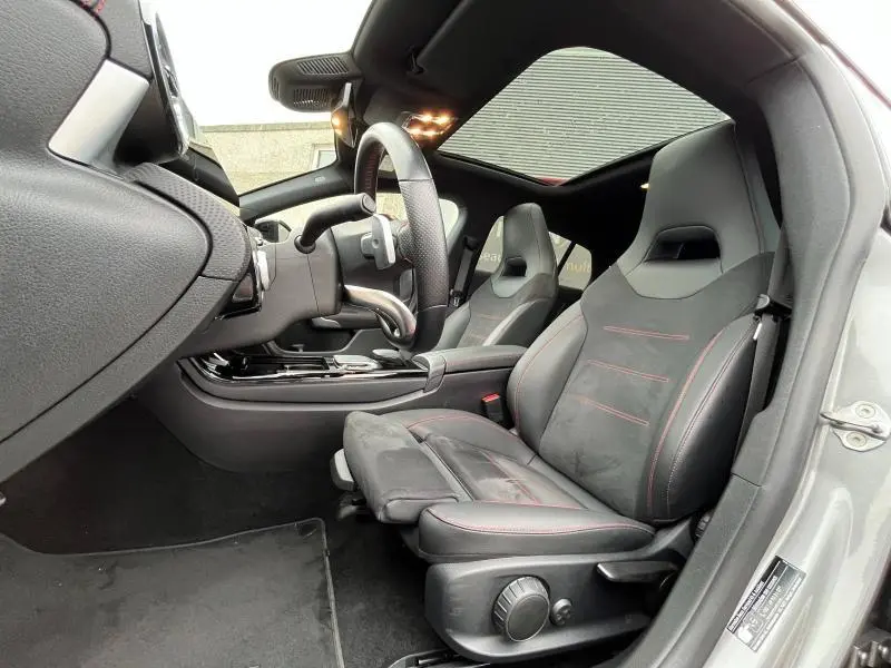 Intérieur côté conducteur de la Mercedes CLA Shooting Brake 250 AMG Line 2022 avec sièges sport noirs et toit ouvrant panoramique.