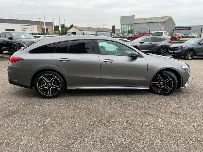 Profil côté gauche d'une Mercedes Classe CLA Shooting Brake 250 AMG Line 4Matic gris montagne métallisé avec jantes AMG noires.
