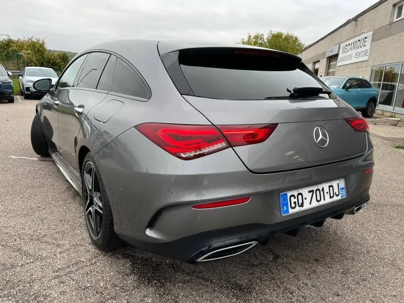 Vue 3/4 arrière droite d'une Mercedes CLA Shooting Brake 250 AMG Line gris montagne métallisé avec feux LED et double sortie d'échappement chromée.