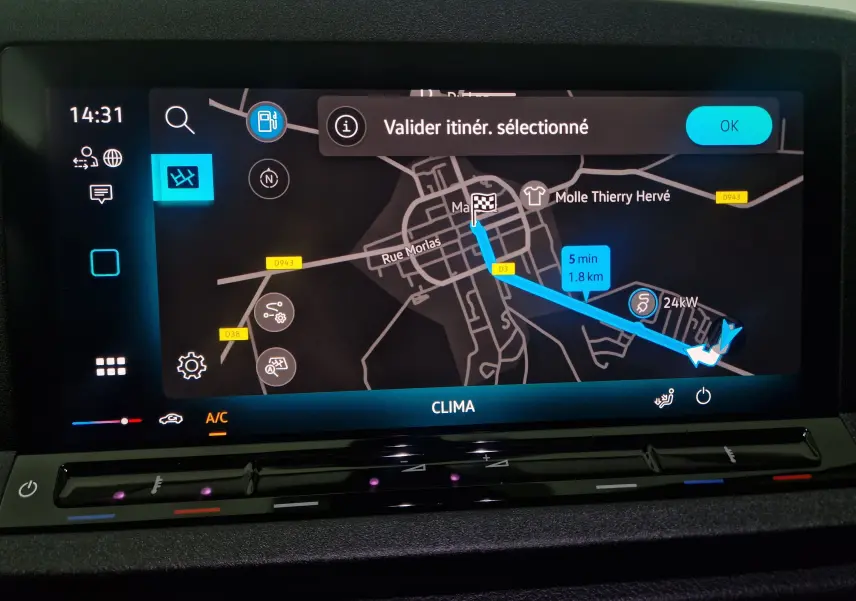 Écran tactile de navigation du Volkswagen Caddy Maxi 2025 montrant un itinéraire sur fond sombre avec commandes climatisation.