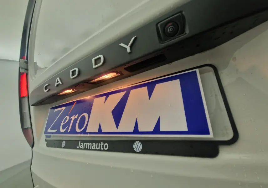 Vue rapprochée arrière du Volkswagen Caddy Maxi blanc avec caméra de recul et éclairage plaque visible.