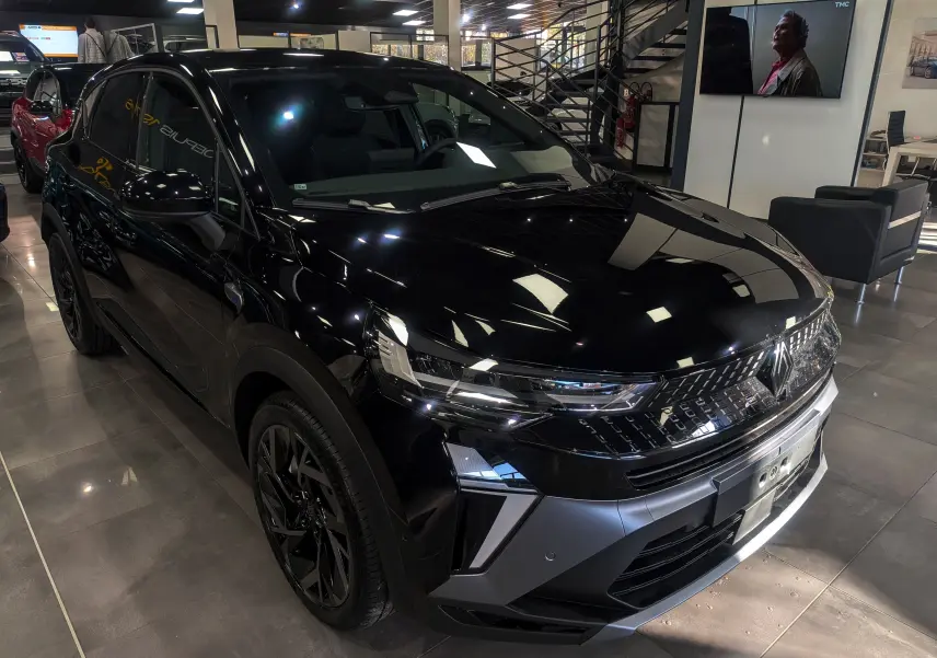 Renault Captur E-Tech Full Hybrid noir étoilé vu en 3/4 avant droit dans un showroom moderne.