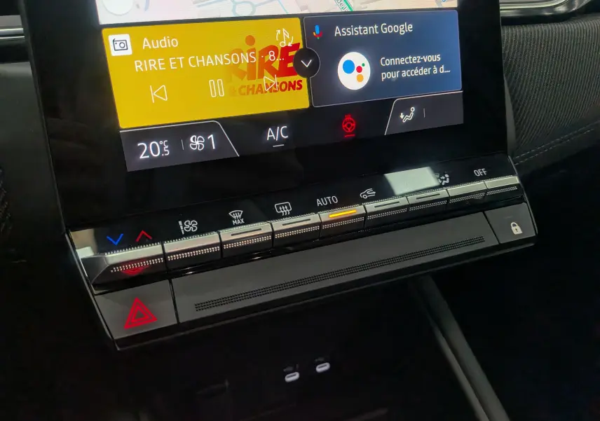 Détail de la console centrale du Renault Captur E-TECH 2025, avec écran tactile affichant la radio et commandes climatisation.