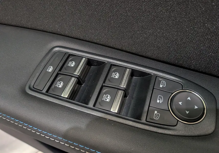 Panneau de commandes des vitres électriques et rétroviseurs sur la porte intérieure d'un Renault Captur noir étoilé 2025.