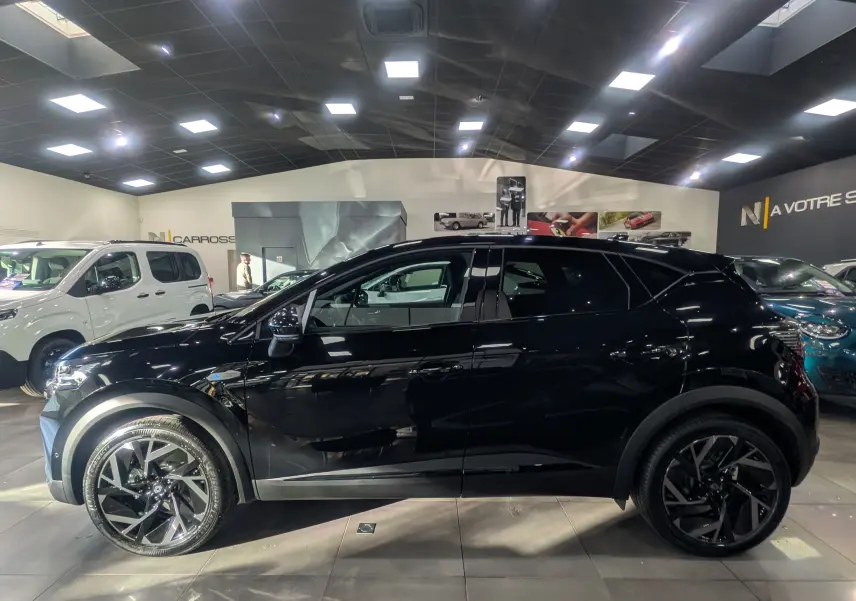 Profil côté gauche du Renault Captur E-TECH Full Hybrid 160 CH esprit Alpine noir étoilé en showroom, roues alliage noires.