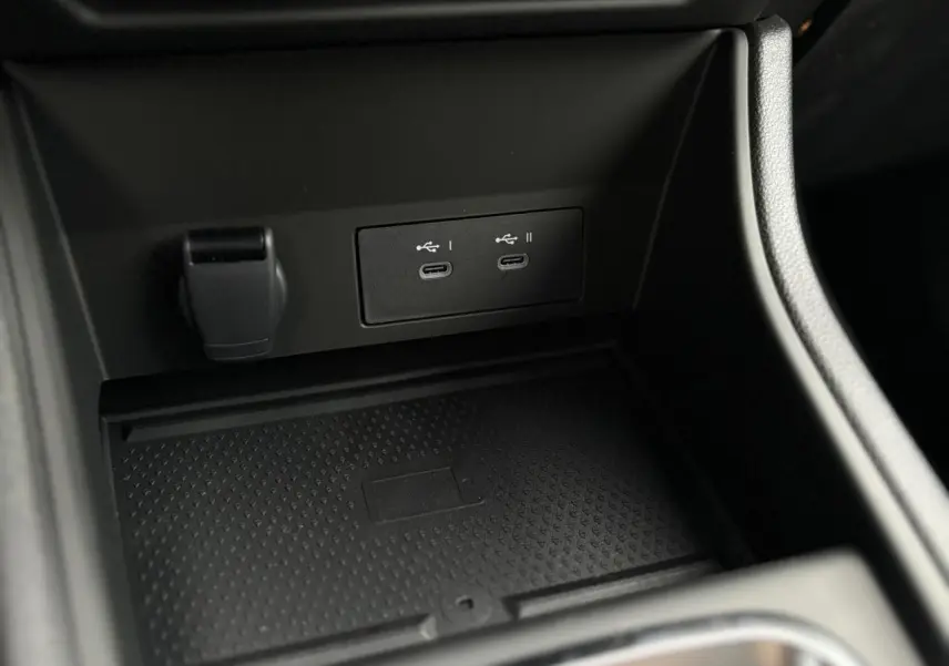 Prise USB double et prise 12V dans la console centrale noire du Renault Captur Bleu Iron 2025.