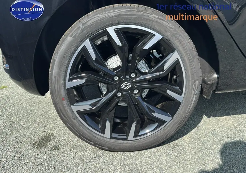 Gros plan sur la jante alu noire et argentée de la Renault Clio V noire, côté arrière droit du véhicule.