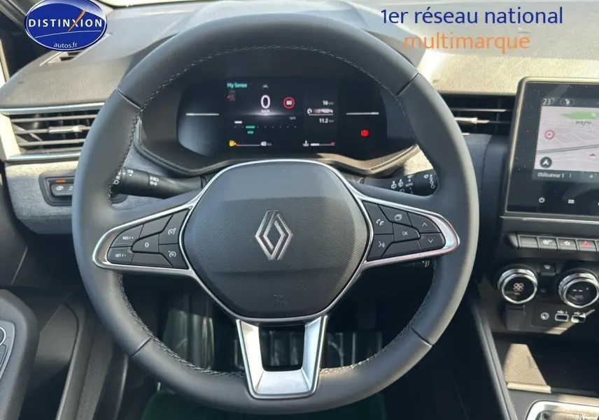 Vue centrée sur le volant multifonction noir de la Renault Clio V 2025 avec tableau de bord numérique et écran tactile.