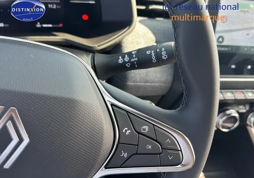 Gros plan sur le volant multifonction noir de la Renault Clio V 1.0 TCe 90 Techno avec commandes intégrées et tableau de bord partiel.