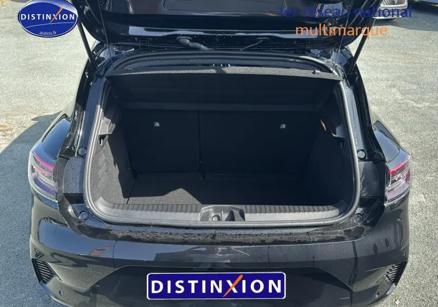 Coffre ouvert vu de l'arrière d'une Renault Clio V noire, avec feux arrière à LED visibles.