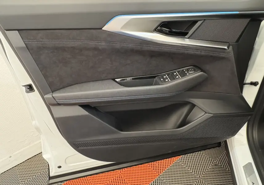 Vue rapprochée de la porte avant gauche blanche du Renault Espace esprit Alpine, avec garniture noire et commandes électriques.