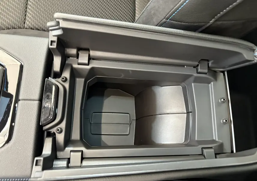 Vue plongeante sur le rangement central ouvert du Renault Espace blanc esprit Alpine 7PL E-Tech 2025, intérieur noir.