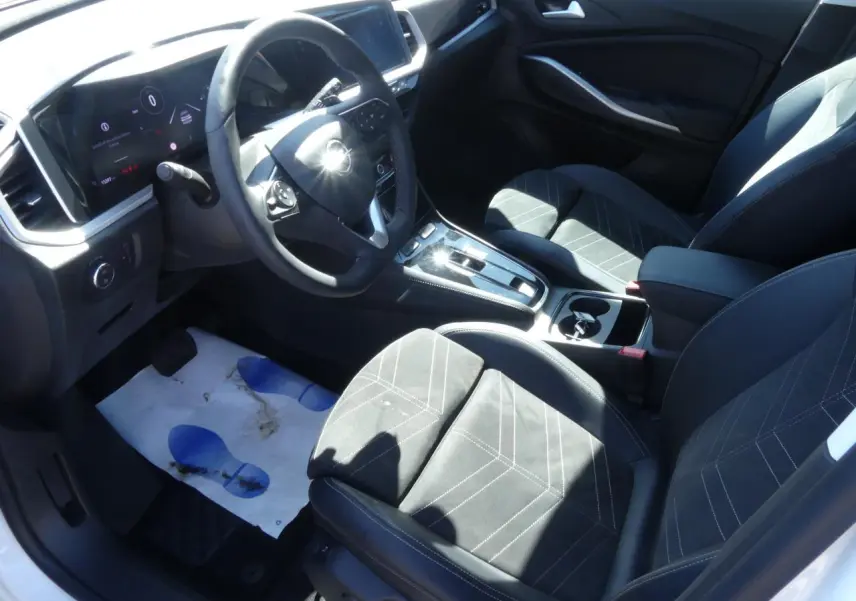 Intérieur de l’Opel Grandland 2024 vu côté conducteur, sellerie Alcantara noire avec coutures blanches et console centrale moderne.