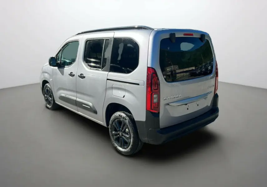 Vue 3/4 arrière droite d’un Citroën Berlingo 2025 gris artense avec vitres arrière surteintées et jantes alu noires.
