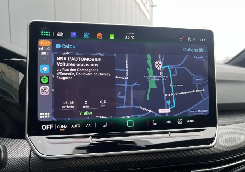 Écran tactile intérieur de la Volkswagen Golf VIII noir, affichant le GPS avec itinéraire et commandes climatisation.