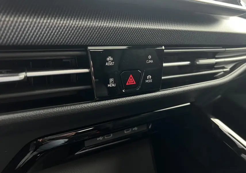 Détail du tableau de bord noir de la Volkswagen Golf VIII R-Line montrant les commandes d’assistance et climatisation.