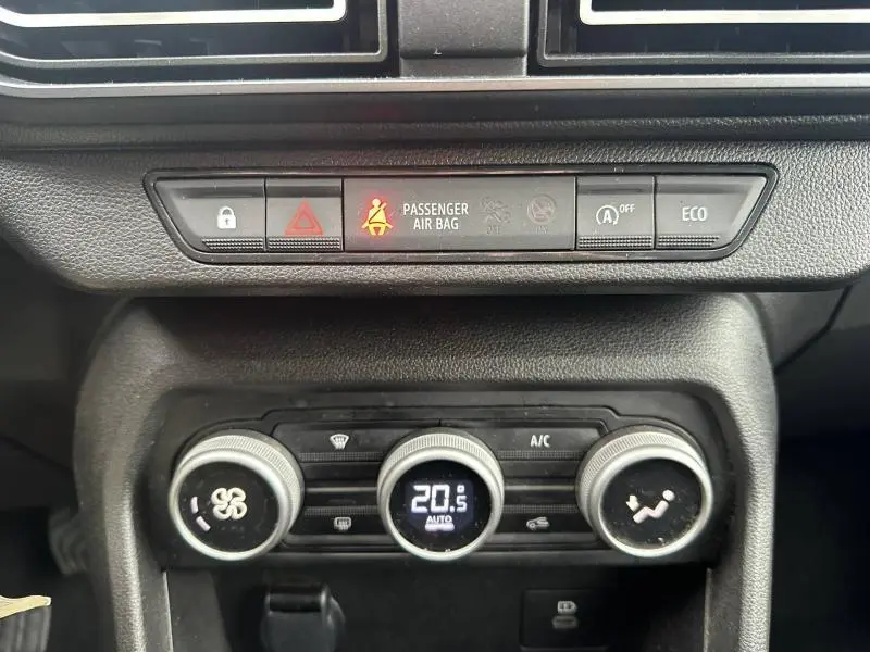 Vue rapprochée du tableau de bord du Dacia Jogger 2025, montrant les commandes de climatisation et les voyants de sécurité.