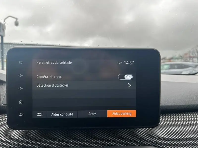 Écran tactile central du Dacia Jogger 2025 affichant les paramètres d’aide au stationnement, intérieur sobre et moderne.
