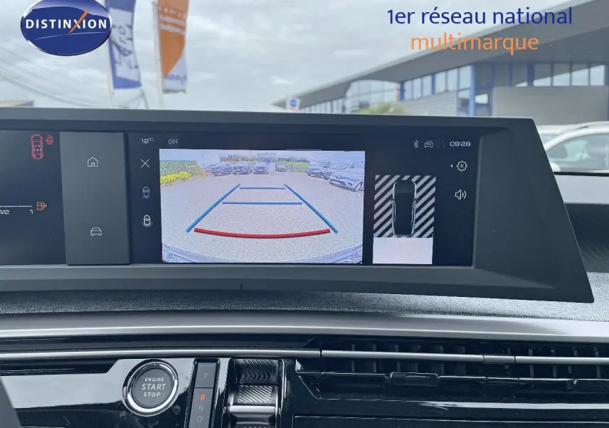 Vue intérieure du tableau de bord du Peugeot 3008 Hybrid 2025, écran de caméra de recul affiché en plein jour.