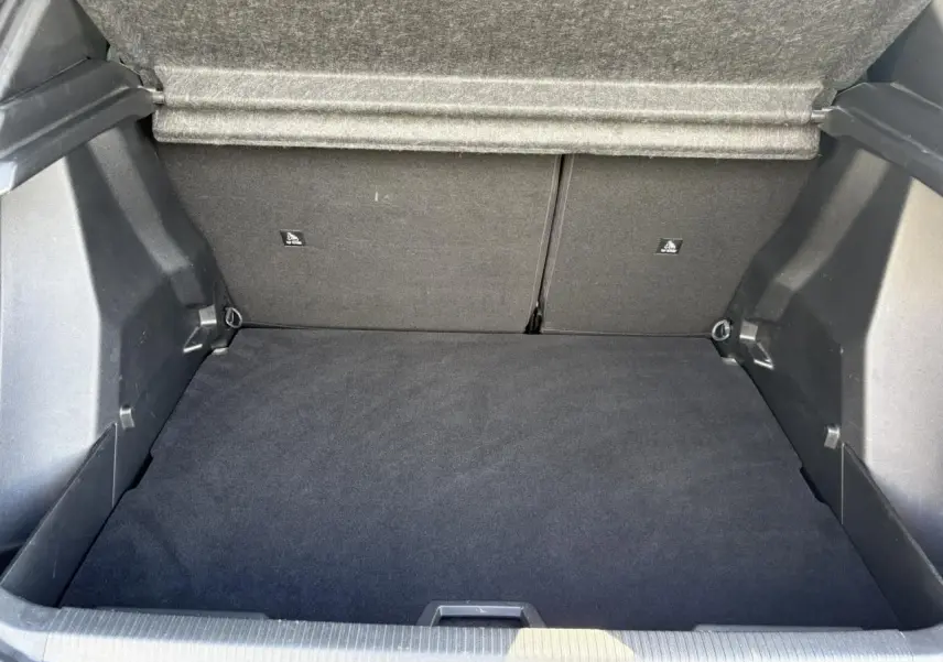 Coffre ouvert d'un Peugeot 2008 noir Onyx, montrant l'espace de chargement propre et la doublure intérieure grise.