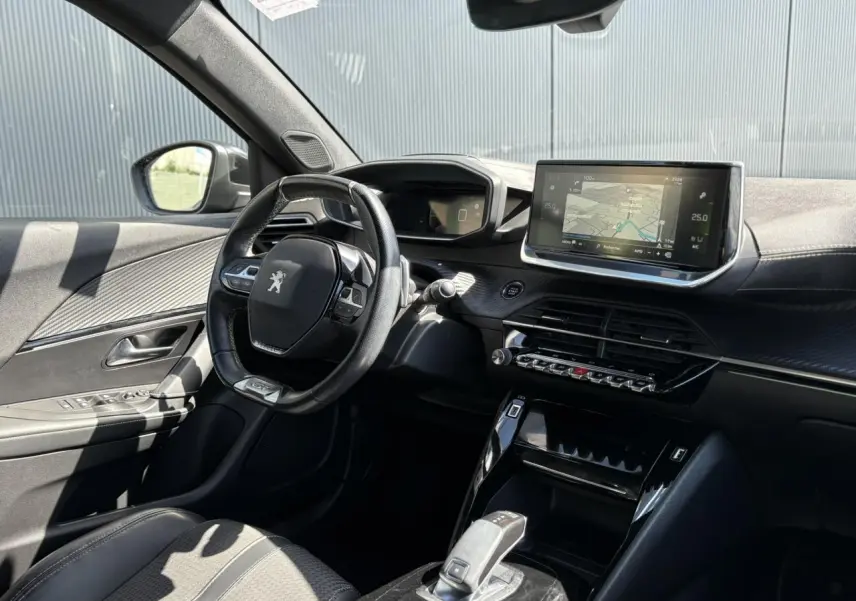 Intérieur avant gauche du Peugeot 2008 noir Onyx 2021, tableau de bord avec écran GPS tactile et volant compact cuir.