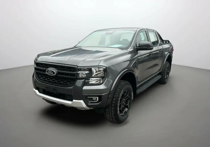 Ford Ranger 2025 gris carbone en 3/4 avant droit avec calandre noire et pneus tout-terrain marqués Tremor