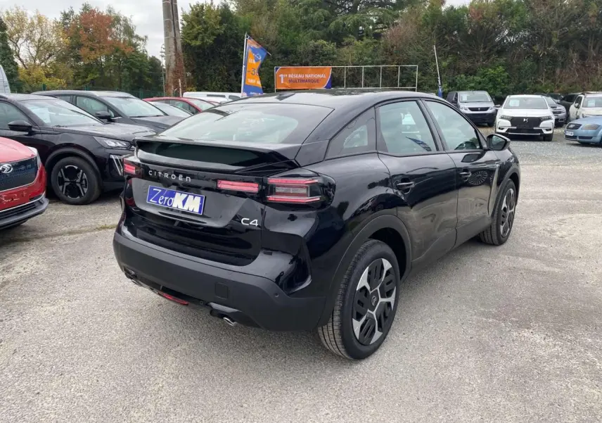 Vue 3/4 arrière droite d'une Citroën C4 noire Perla Nera avec toit noir et feux arrière LED distinctifs.