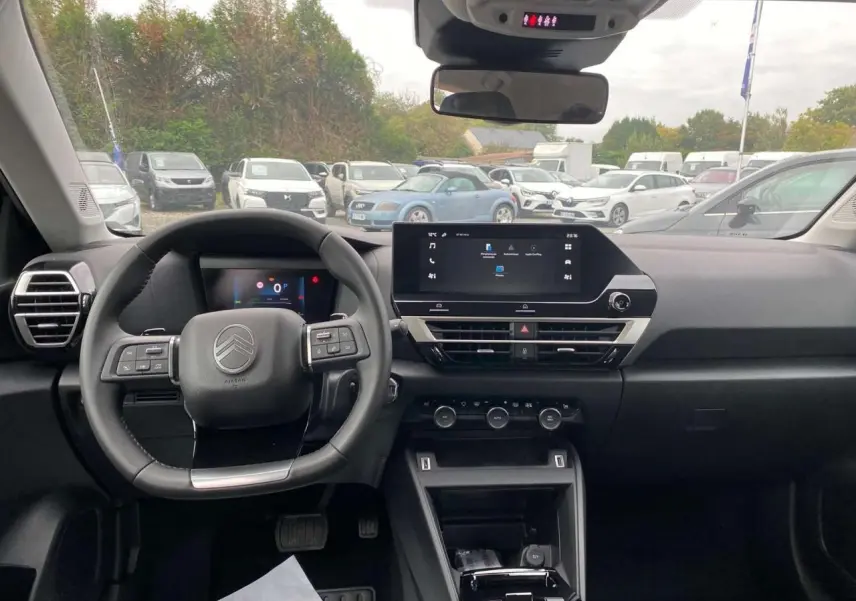 Vue intérieure avant du poste de conduite de la Citroën C4 noire, avec écran tactile central et volant multifonction.