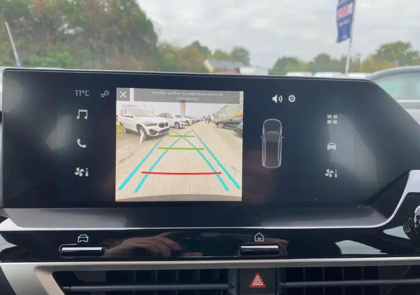 Écran central de la Citroën C4 hybride 2025 montrant la caméra de recul avec lignes de guidage colorées.