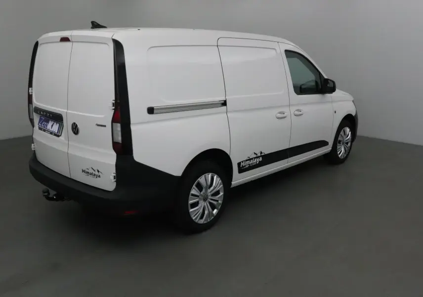 Vue 3/4 arrière droite d'un Volkswagen Caddy Maxi blanc avec logo Himalaya et attelage visible.