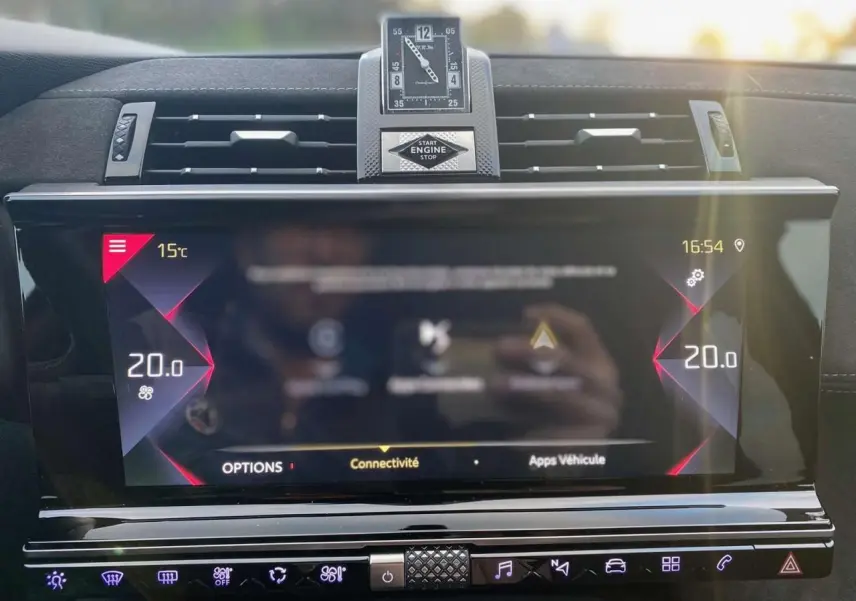 Tableau de bord du DS7 Crossback blanc 2022, vue frontale sur l'écran tactile et horloge analogique centrale.