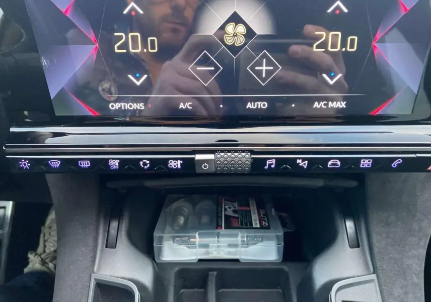 Gros plan sur la console centrale du DS7 Crossback blanc 2022, affichage digital avec commandes tactiles et rangement inférieur.