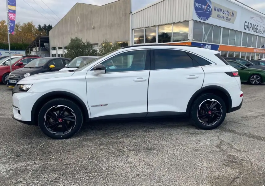 Vue de profil côté gauche d'un DS7 Crossback blanc 2022 avec jantes noires et finition Performance Line.