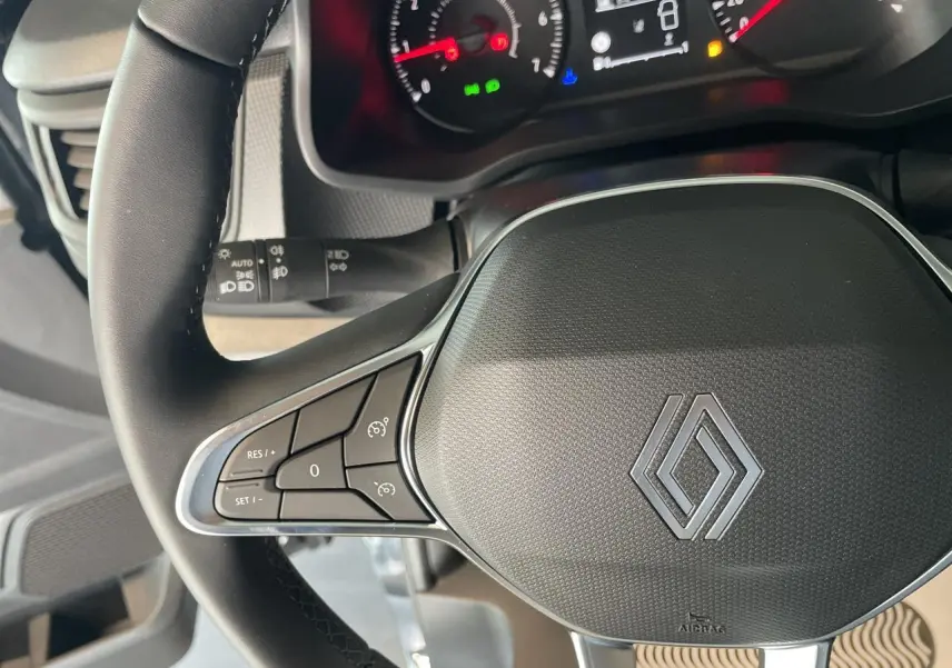 Vue rapprochée du volant noir du Renault Trafic Fourgon 2025 avec commandes intégrées et tableau de bord partiel.