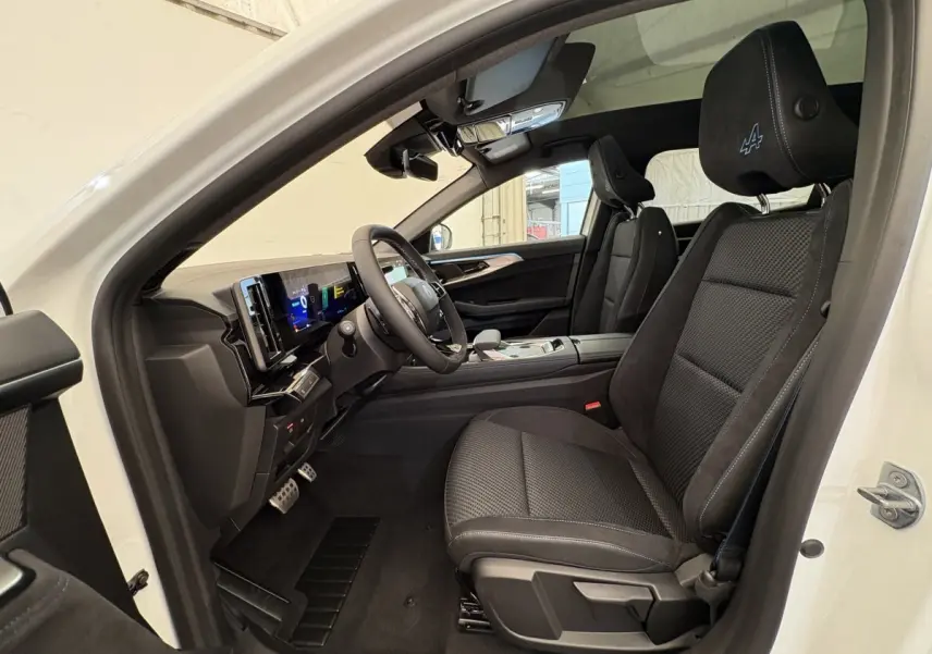 Vue intérieure côté conducteur du Renault Espace Esprit Alpine blanc 2025, sièges noirs avec logo Alpine brodé sur appuie-tête.