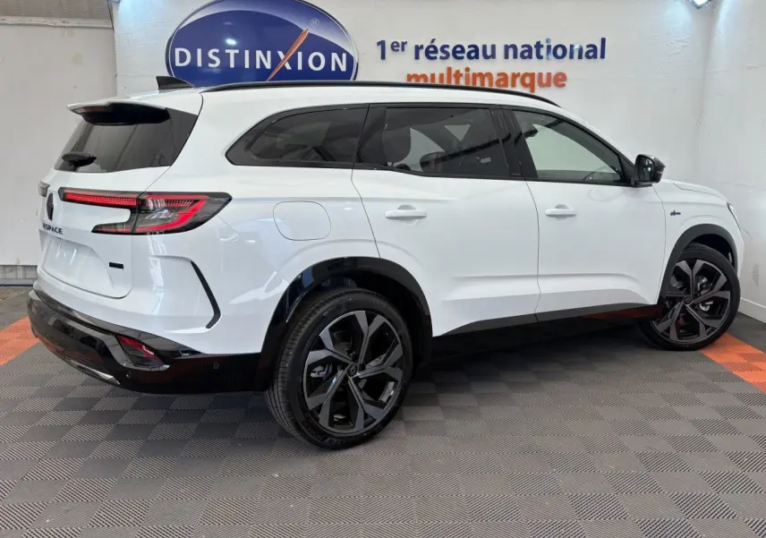 Renault Espace blanc vue 3/4 arrière droit, jantes noires, feux LED, logo E-Tech sur aile avant.