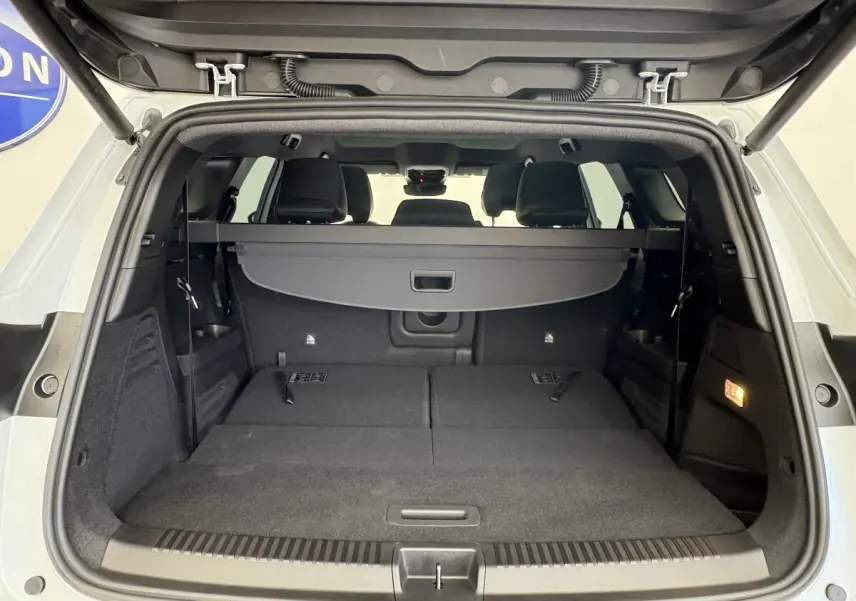 Coffre ouvert d’un Renault Espace blanc 2025, vue arrière montrant banquette arrière rabattue et plancher plat noir.