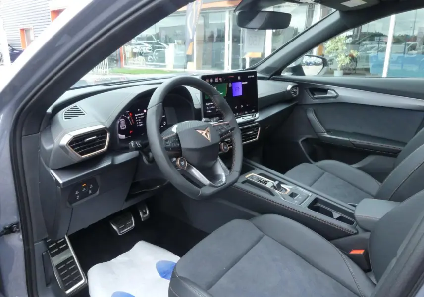 Vue intérieure côté conducteur du CUPRA Formentor gris magnétique, avec volant Supersports et écran tactile HD visible.