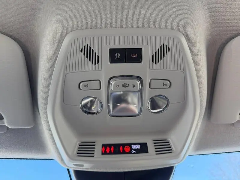 Vue en contre-plongée du plafonnier intérieur gris clair de la Citroën C3 2025 avec boutons SOS et éclairage.