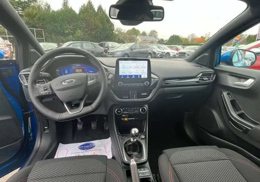 Intérieur du Ford Puma bleu 2022, vue avant centrée sur le tableau de bord et la boîte manuelle.