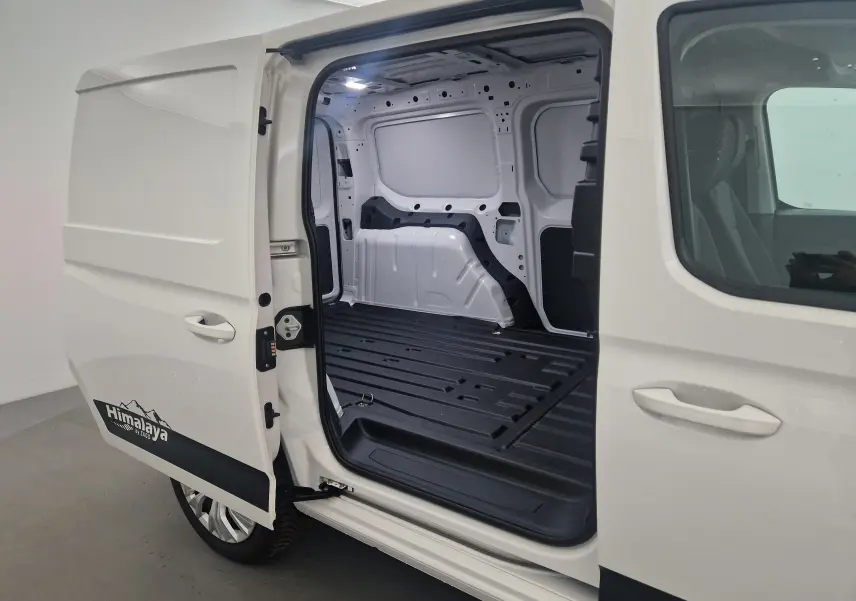 Vue latérale gauche du Volkswagen Caddy Maxi blanc avec porte coulissante ouverte dévoilant l'espace de chargement vide et le logo Himalaya.