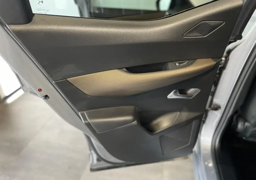 Gros plan sur la porte arrière gauche gris Artense du DS3 Crossback 2020 avec habillage noir et insert marron.