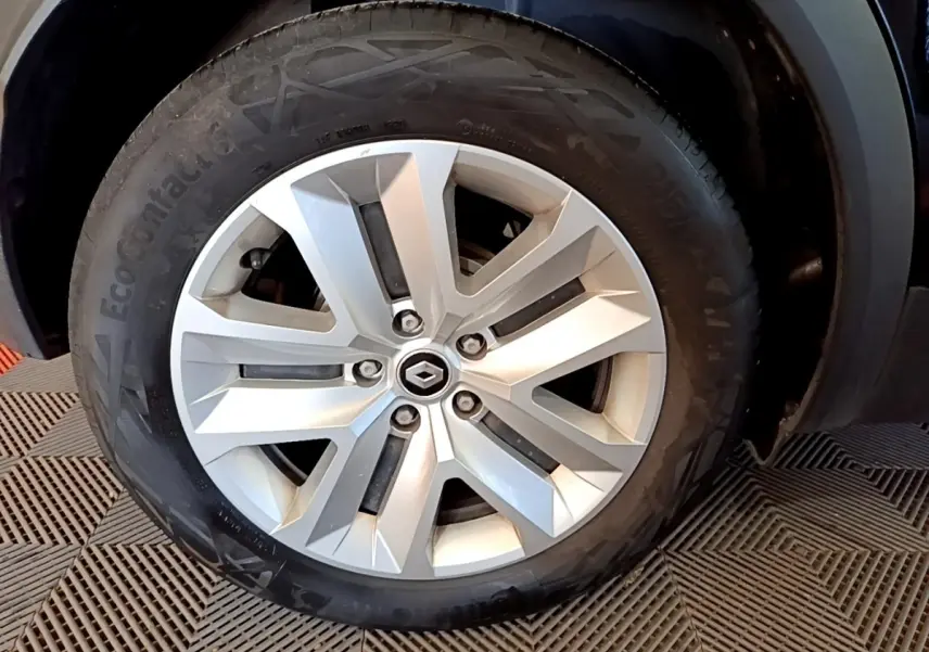 Gros plan sur la roue arrière droite d’un Renault Captur noir, montrant le pneu et l’aile du véhicule.