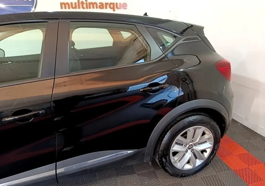 Vue latérale arrière droite d'un Renault Captur Business noir brillant, avec jante alliage et poignées de porte intégrées.
