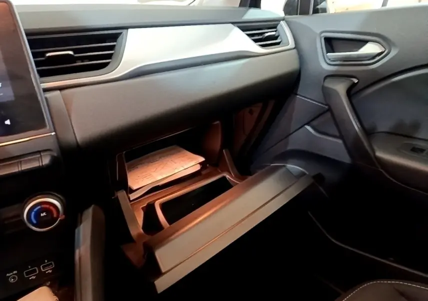 Intérieur noir du Renault Captur Business 2021, vue côté passager avec boîte à gants ouverte et tableau de bord visible.